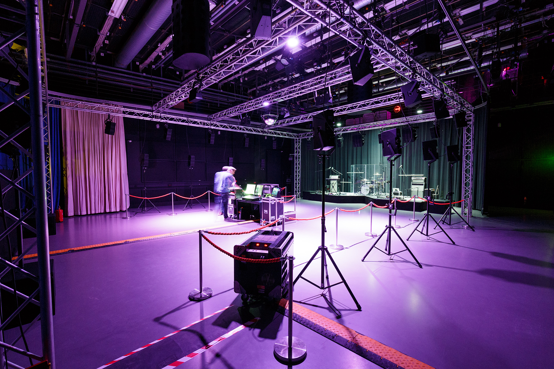 Empty venue before the show with fog machine, speakers on tripods and truss rig for wave field synthesis