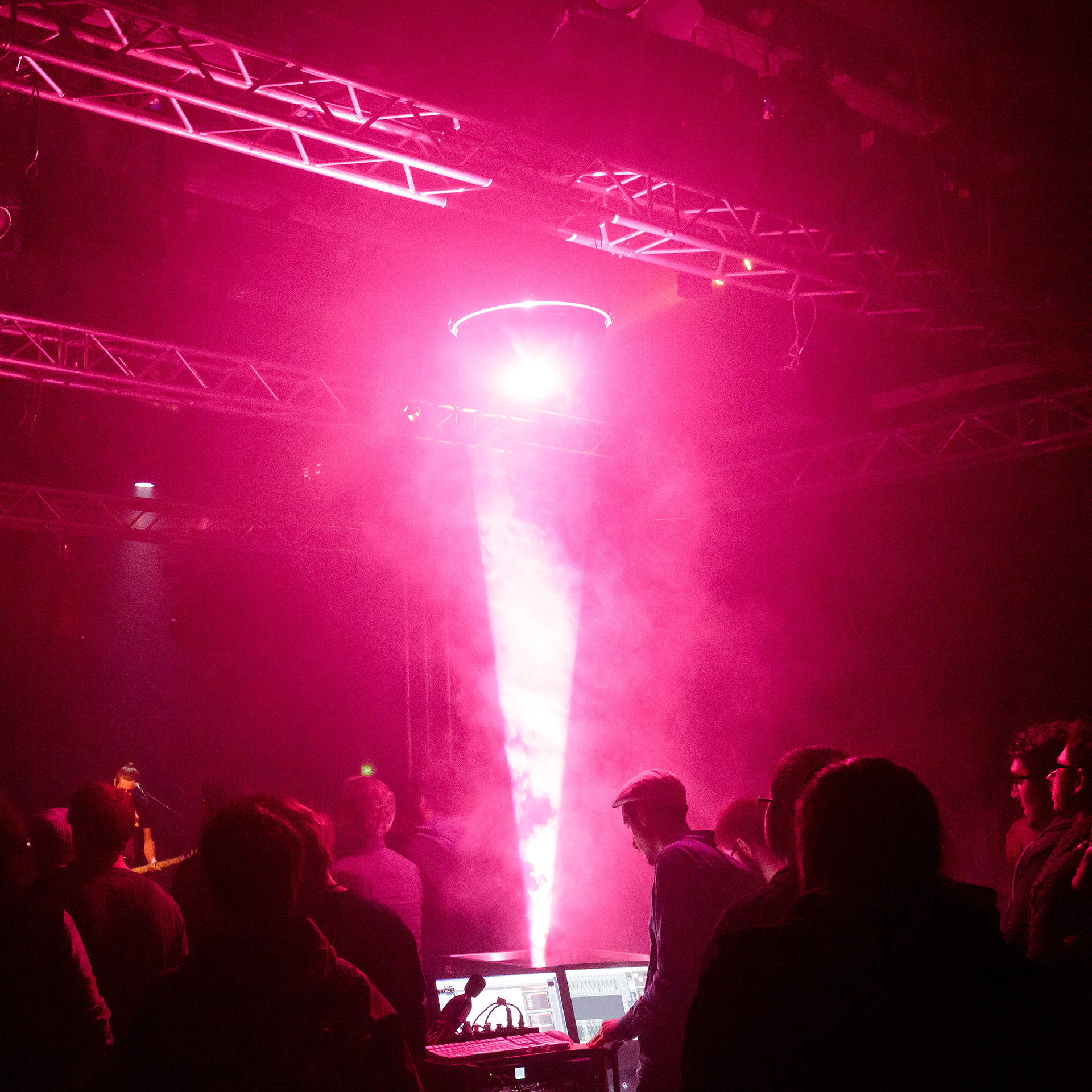 Magenta light cone reflected down from a mirrored hemisphere into heavy fog above the audience and mixing desk