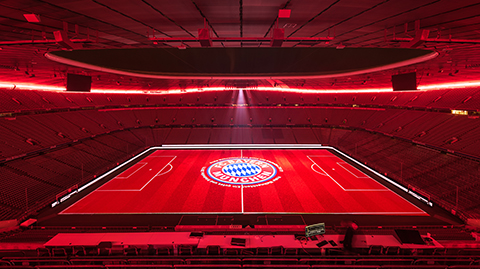 FC Bayern München logo projected on pitch of Allianz Arena