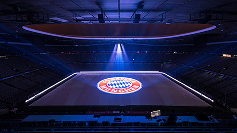 Logo des FC Bayern München als Projektion auf dem Spielfeld der Allianz Arena