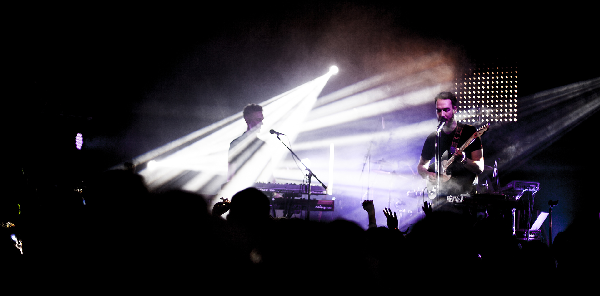 HONNE live on stage with guitar, keyboards and white light beams cutting through the haze