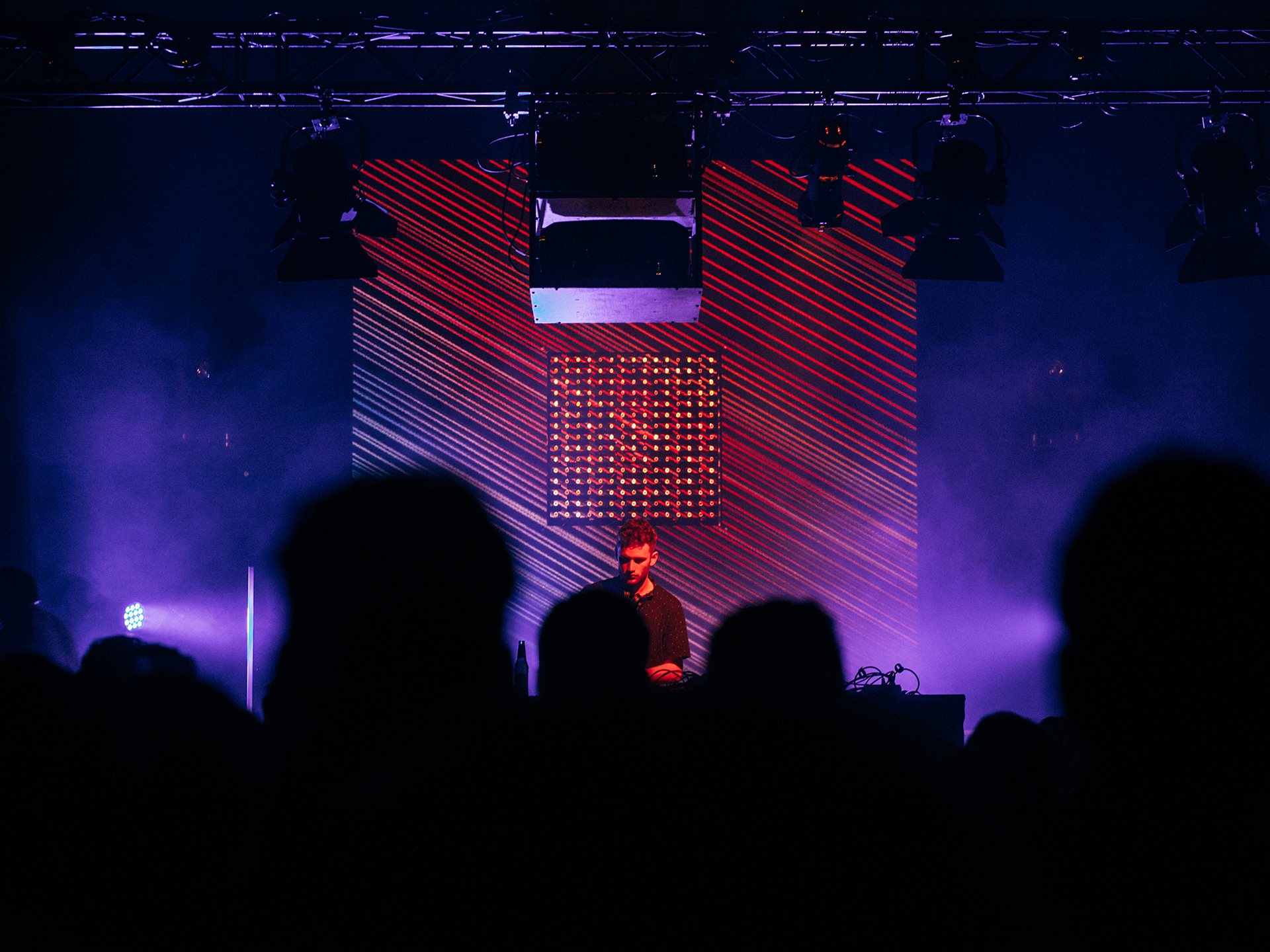 Tom Misch performing in front of a red diagonal-line projection and LED matrix, MLIVE Berlin 2016