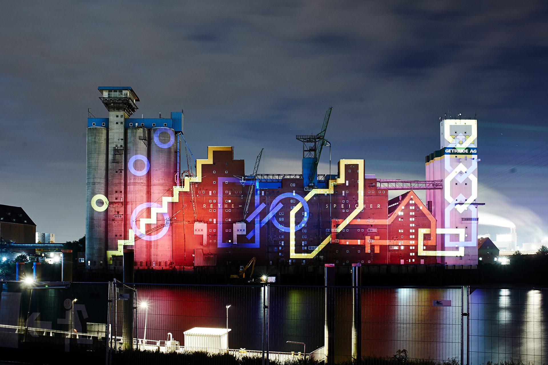 Glowing outlined staircase, circles and chain shapes mapped onto the Rethespeicher and GTH tower