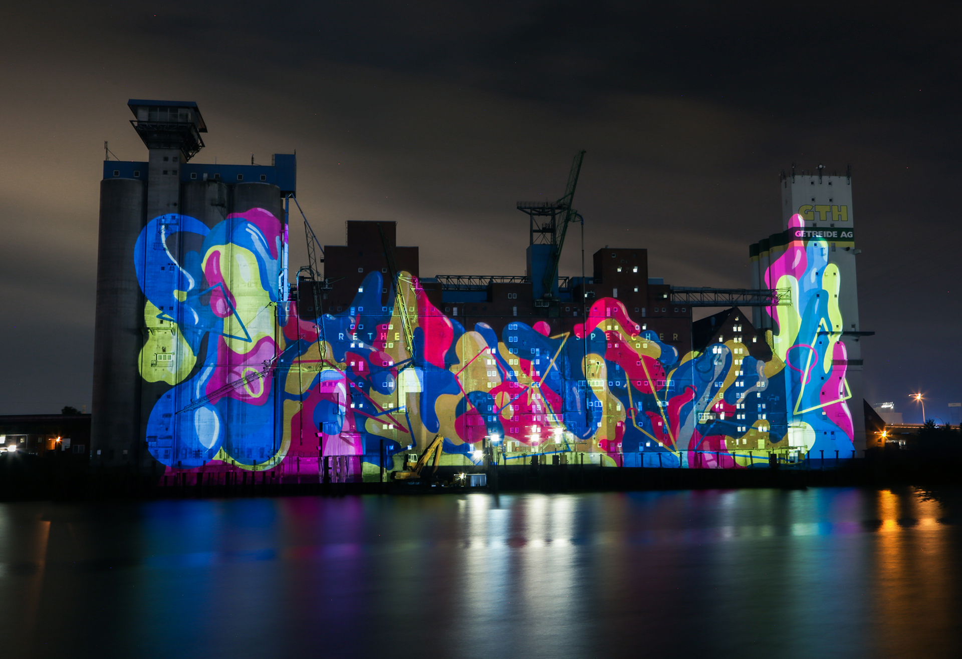 Leuchtende organische Formen in Blau, Pink und Gelb auf der gesamten Fassade des Rethespeichers