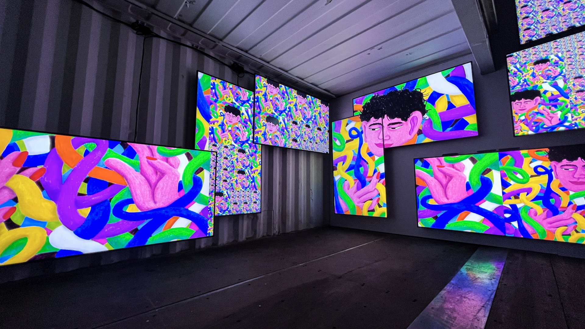 Colourful illustrated music covers on screens inside the container at IN BETWEEN, Reeperbahn Festival 2022