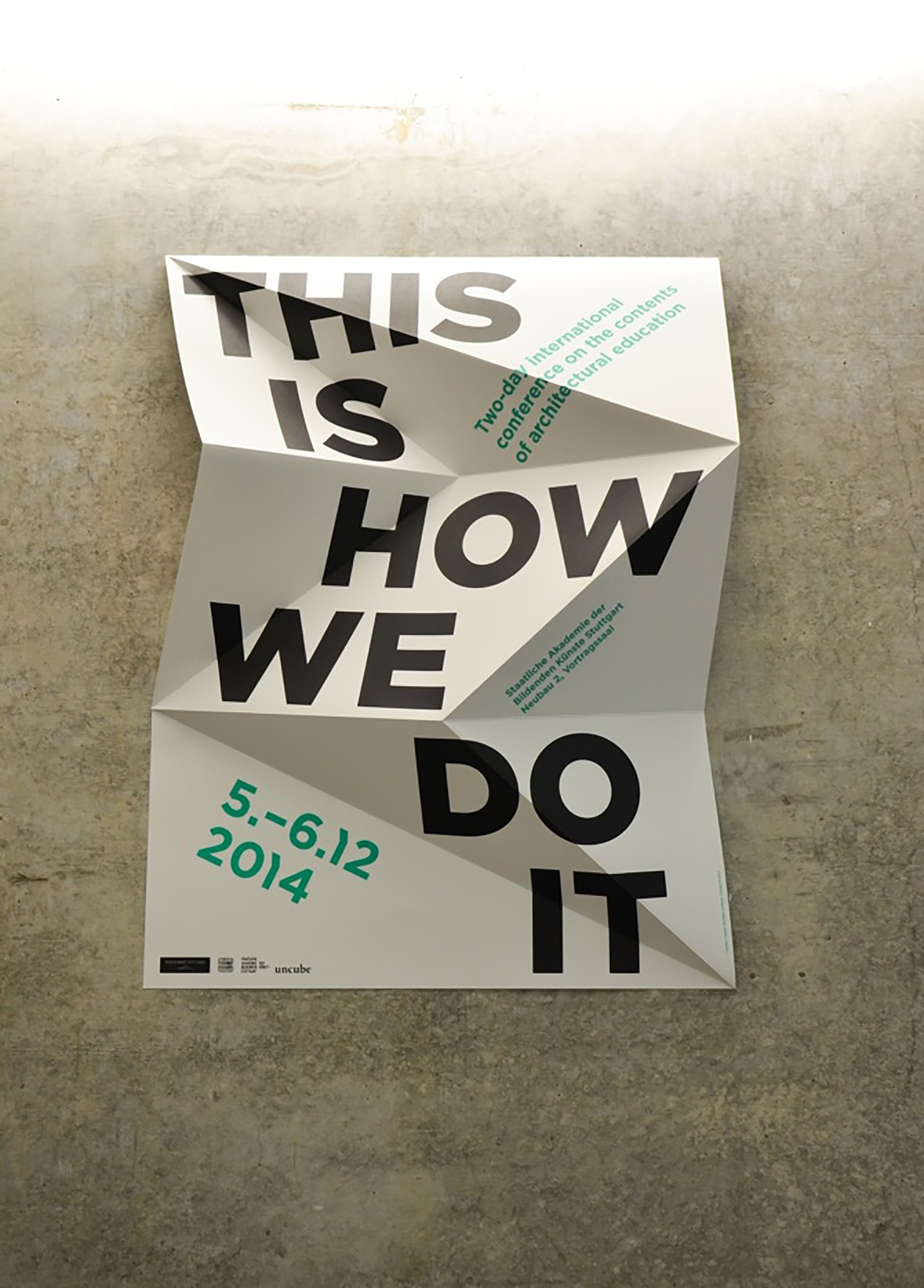 Gefaltetes Konferenzplakat „This Is How We Do It“ von Christian Nicolaus und Ute Müller-Schlösser an einer Betonwand