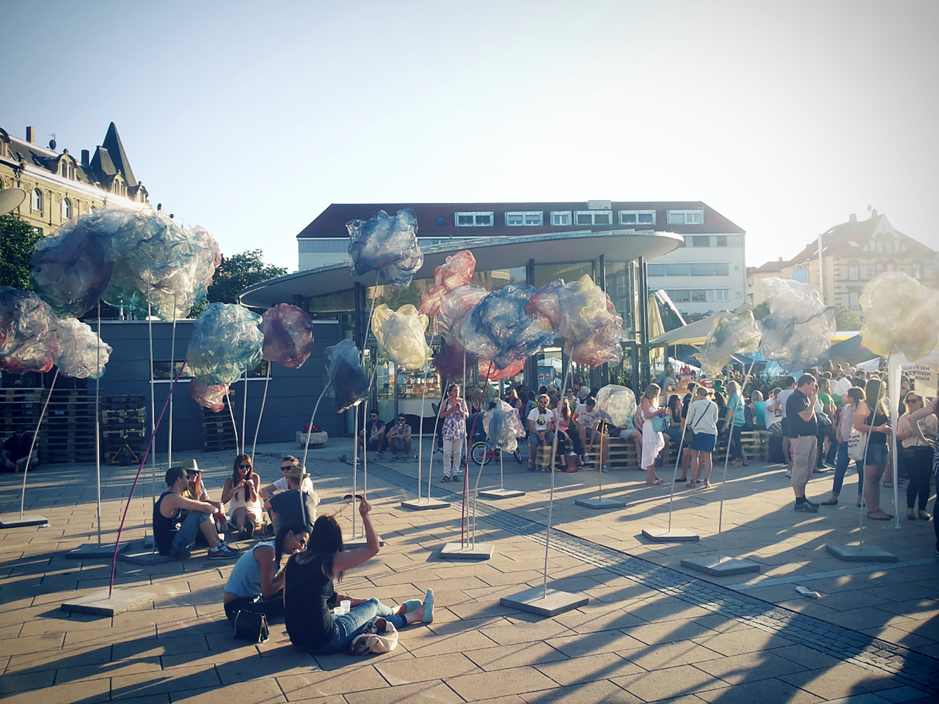Besucher sitzen im Schatten der Installation Überblume auf dem Marienplatz, Stuttgart, 2014